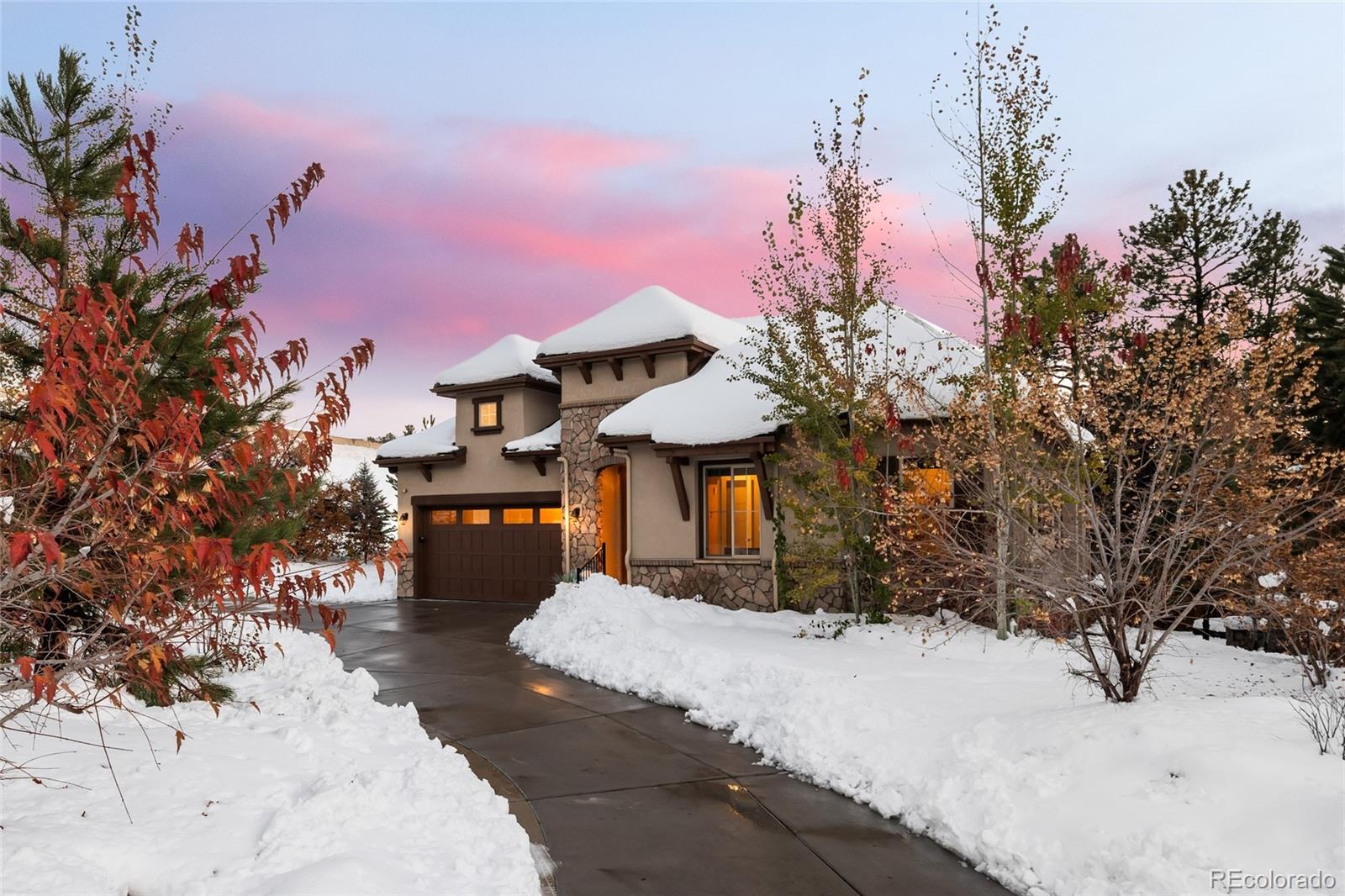 a front view of a house with a yard covered with snow