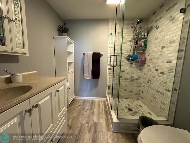 a bathroom with a granite countertop shower toilet and a sink