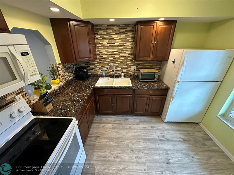 a kitchen with wooden cabinets and a stove top oven