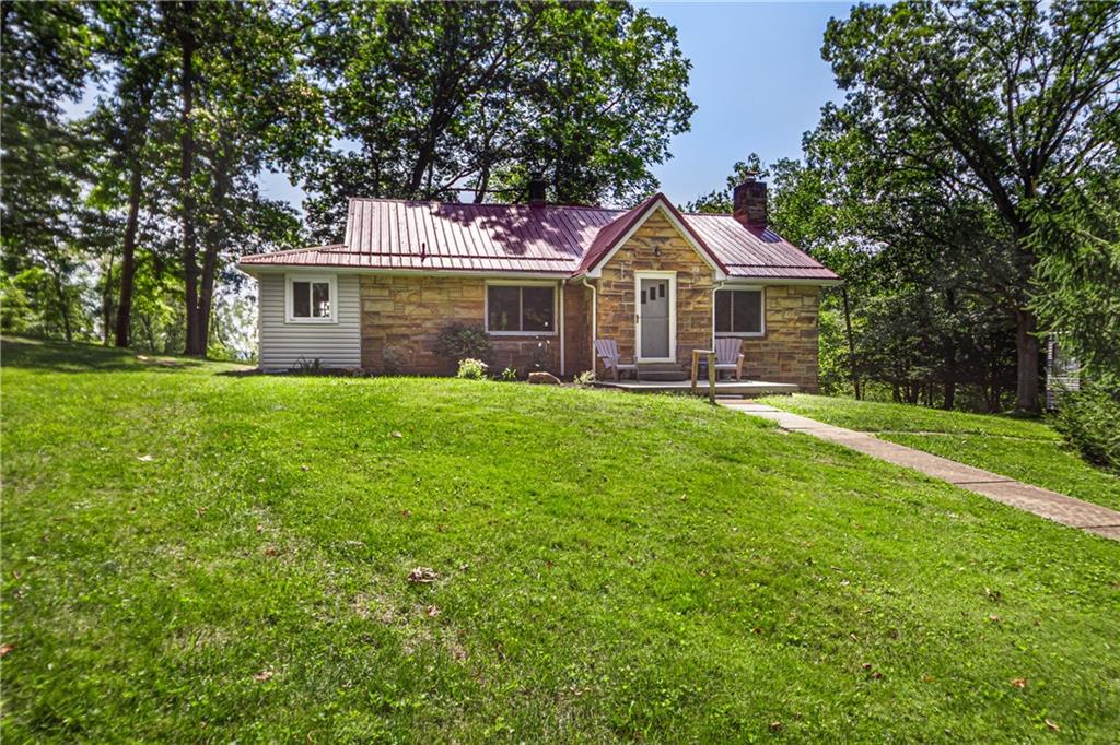 a front view of a house with a yard and trees