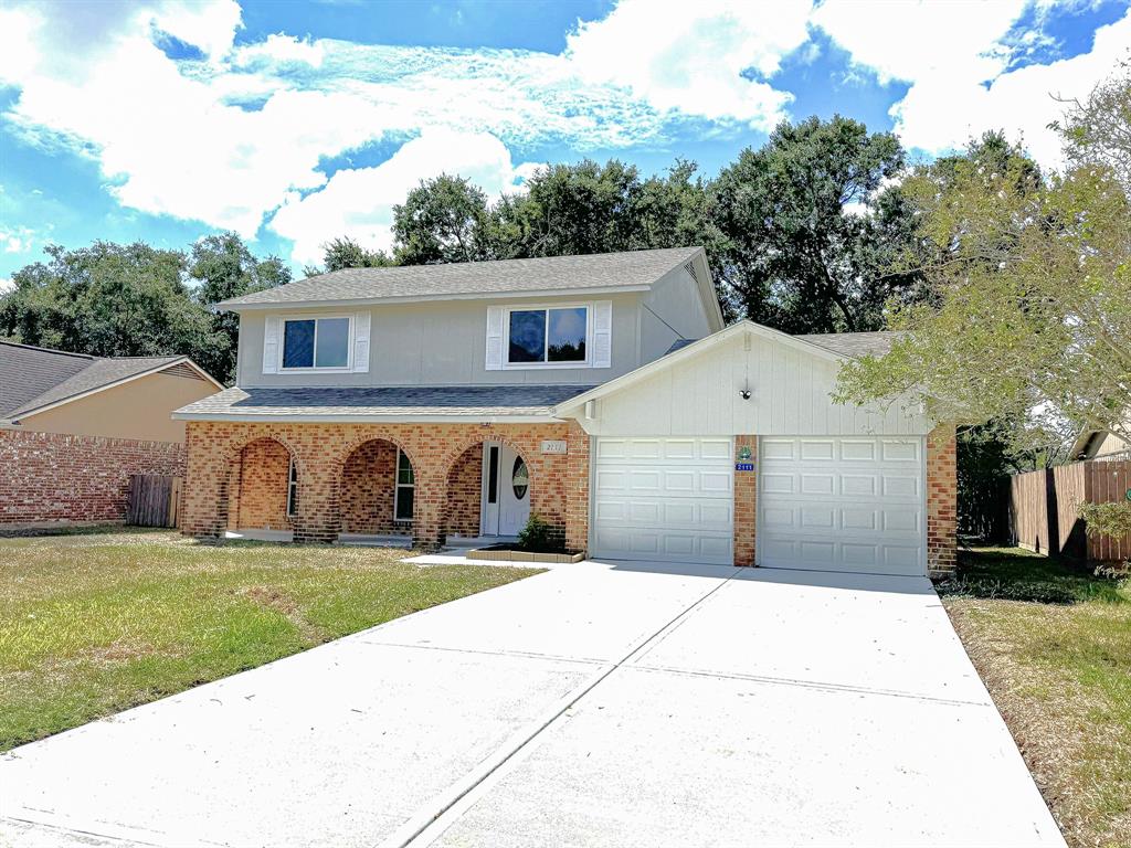 a front view of house with yard and trees in the background