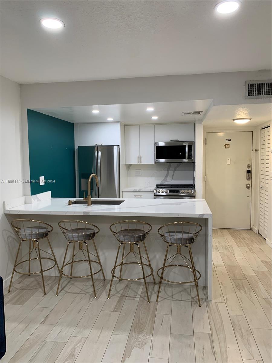 a kitchen with a sink cabinets and wooden floor