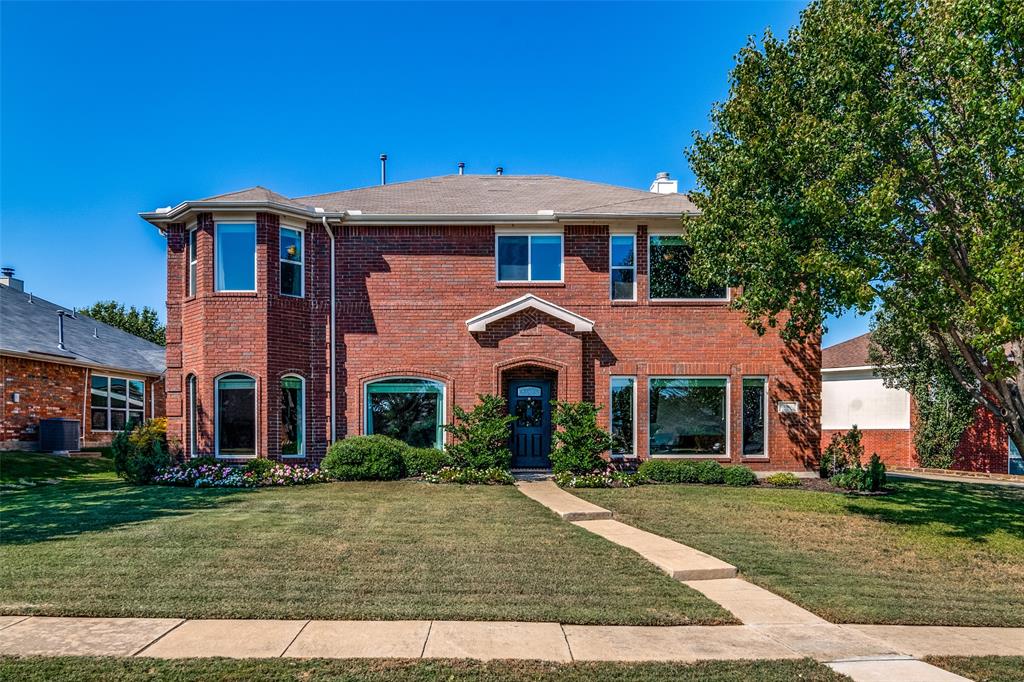 front view of a brick house with a yard