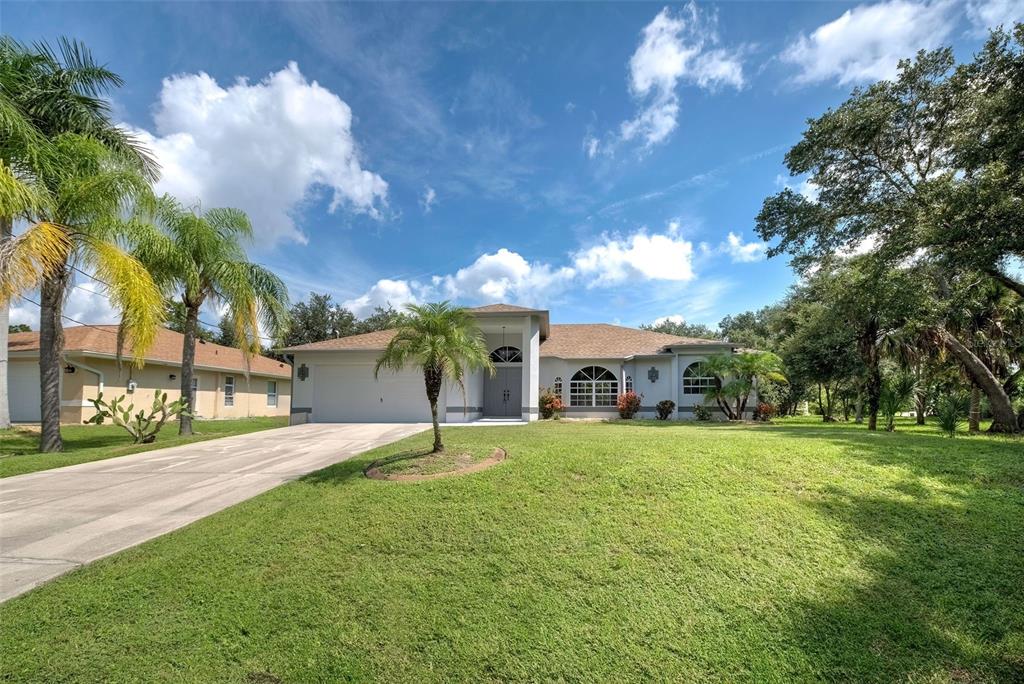 a view of a house with a big yard and a large tree