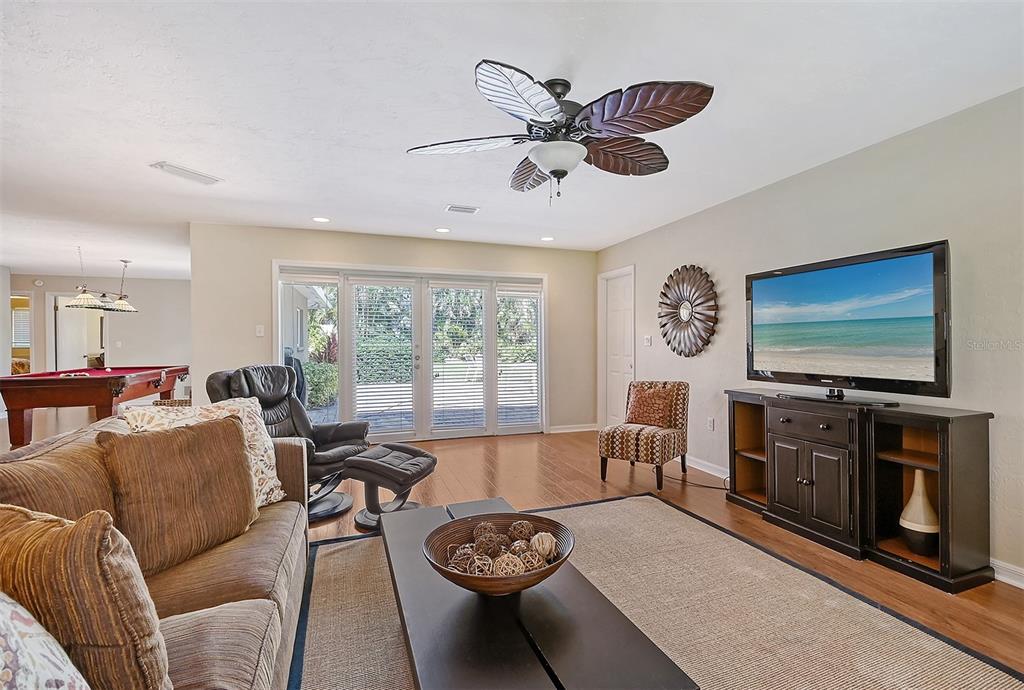 a living room with furniture a flat screen tv and a large window