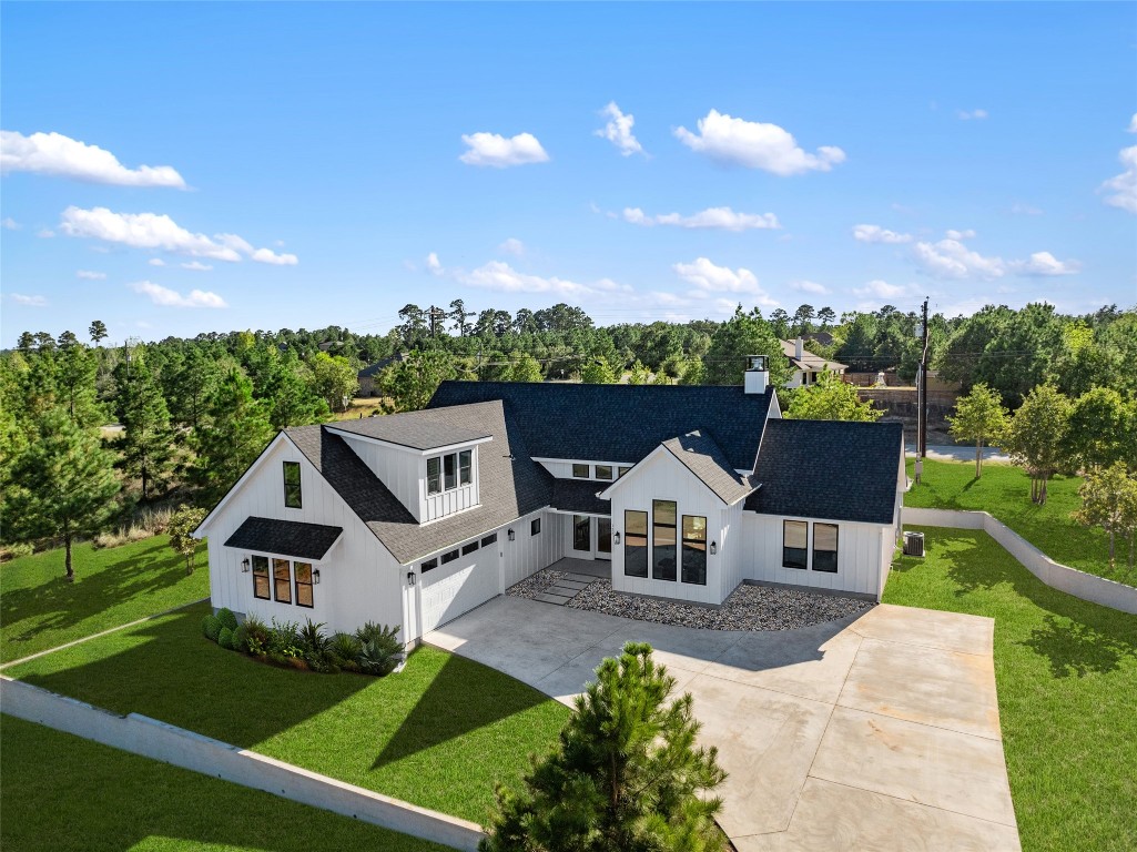 an aerial view of a house with swimming pool and a yard