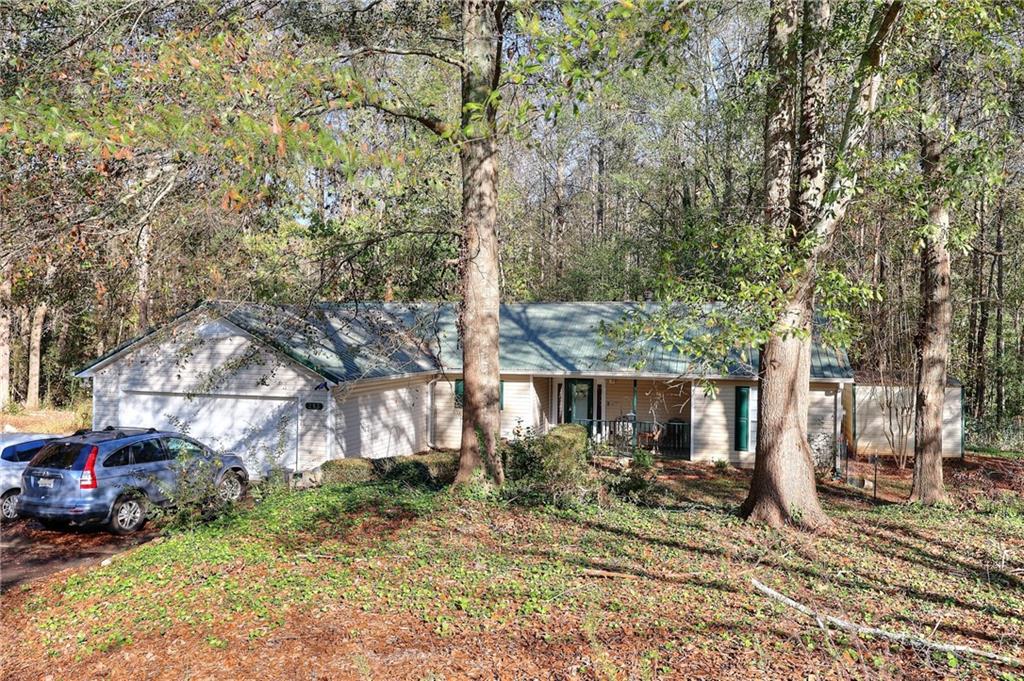 a view of a house with a yard tree and sitting area