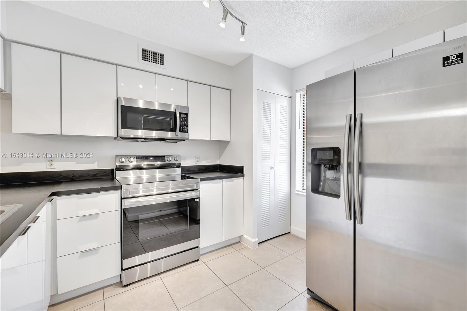 a kitchen with cabinets stainless steel appliances and a counter space