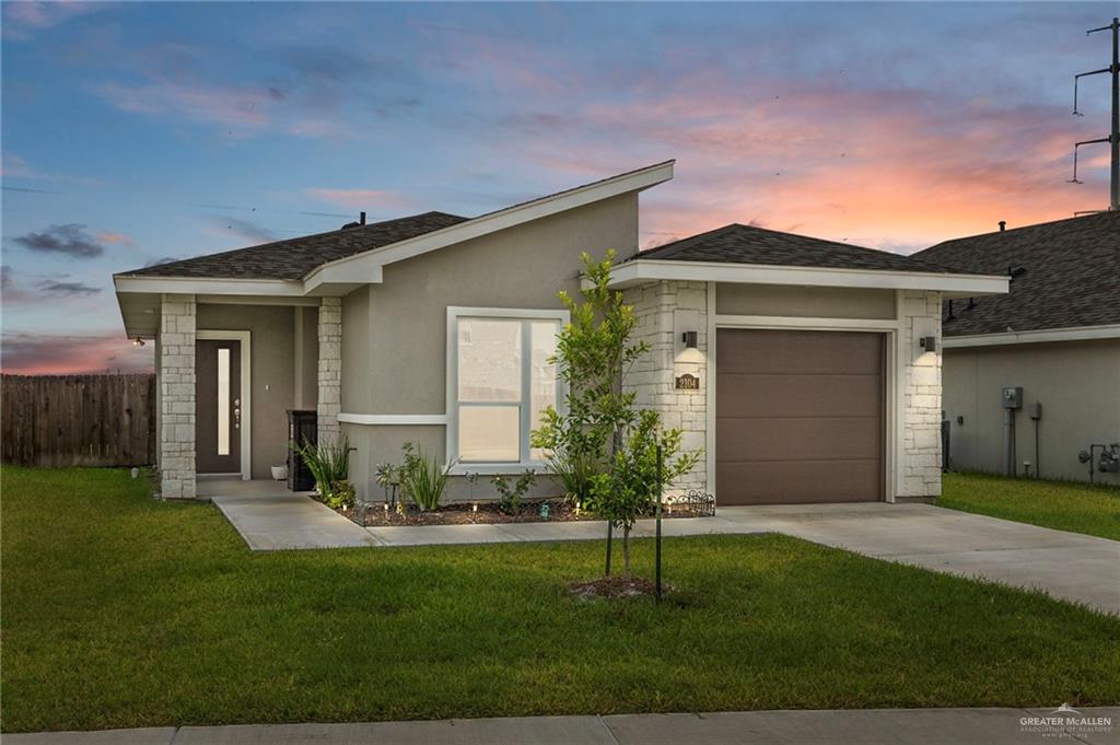 a front view of a house with a garden and yard