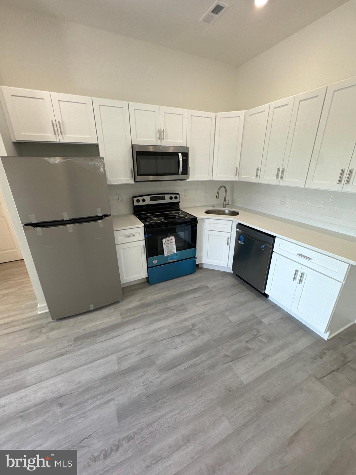 a kitchen with a refrigerator and a stove top oven