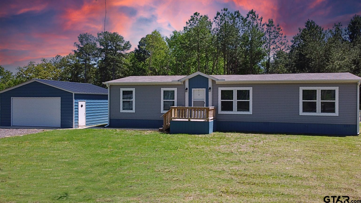 a front view of a house with yard and green space