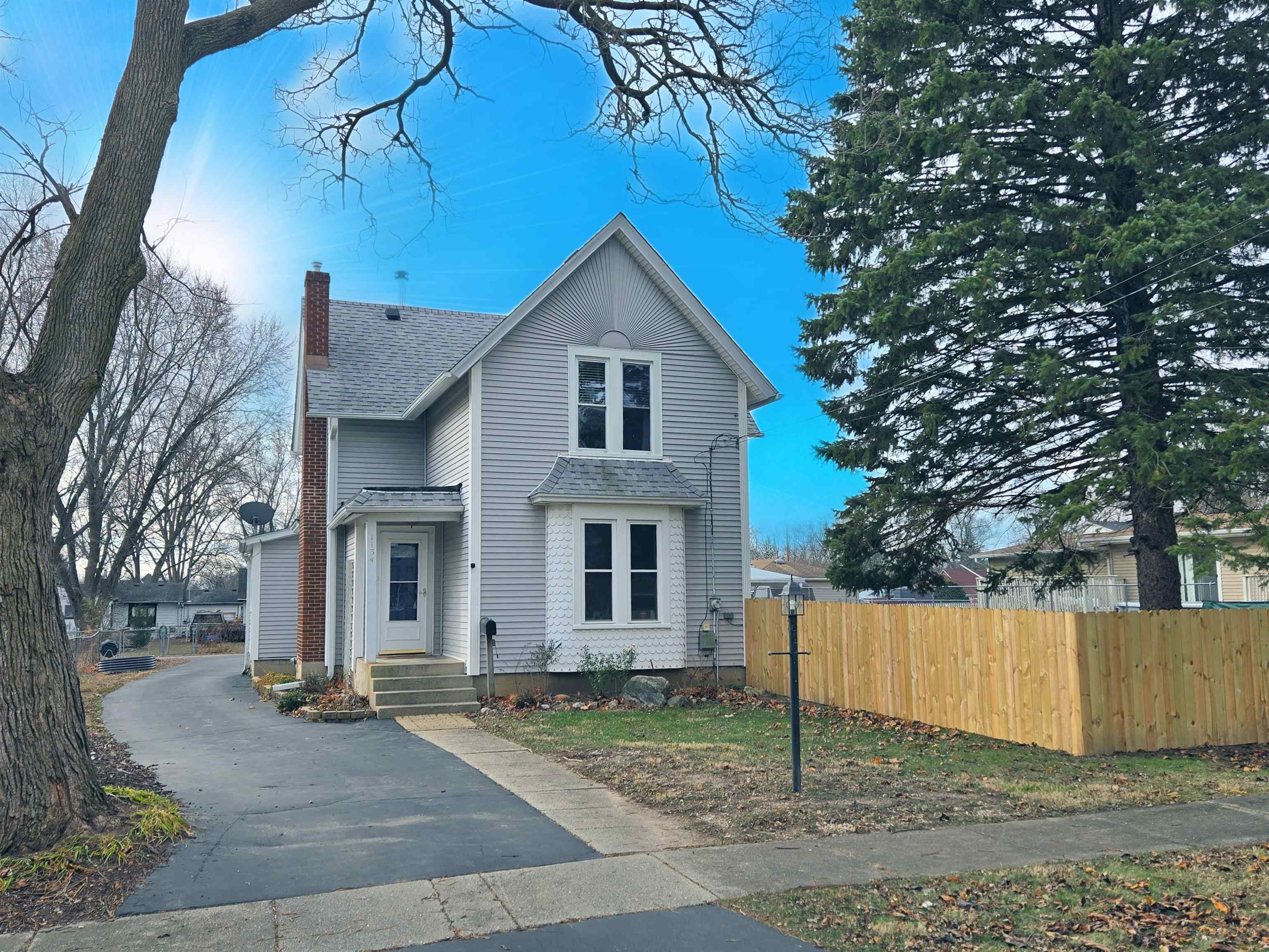 a view of house with a yard and large tree