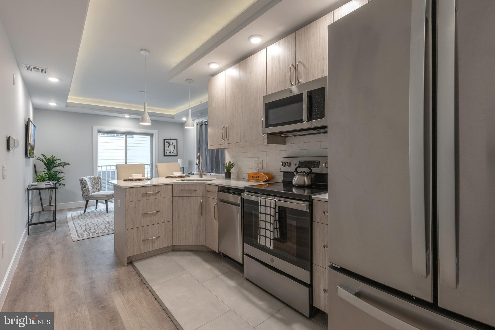 a kitchen with stainless steel appliances granite countertop a stove a sink and a refrigerator