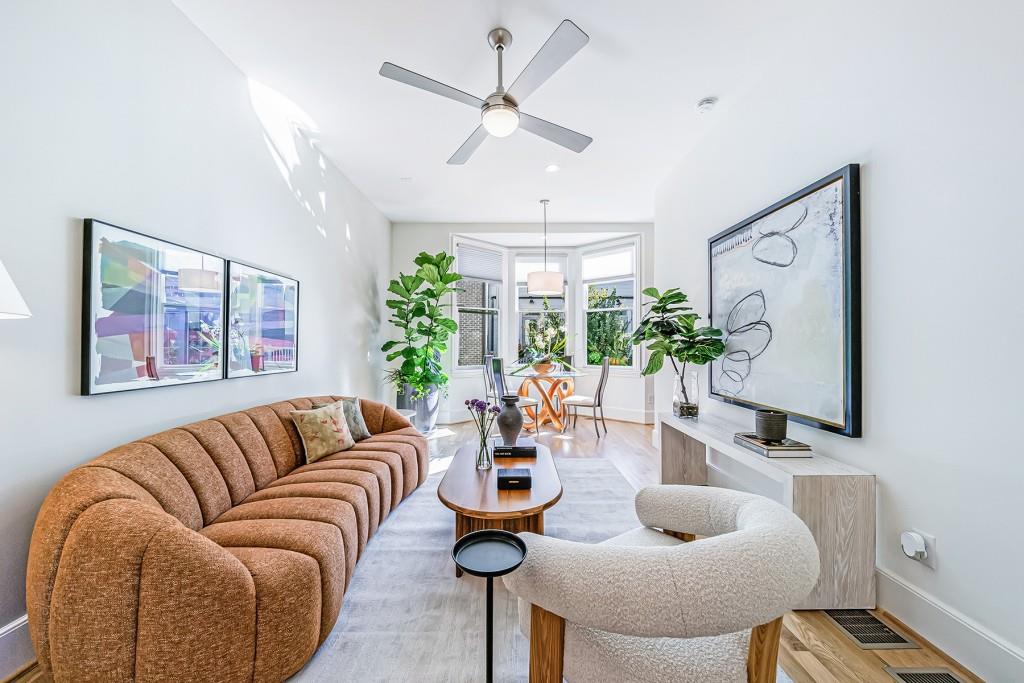 a living room with furniture kitchen view and a large window