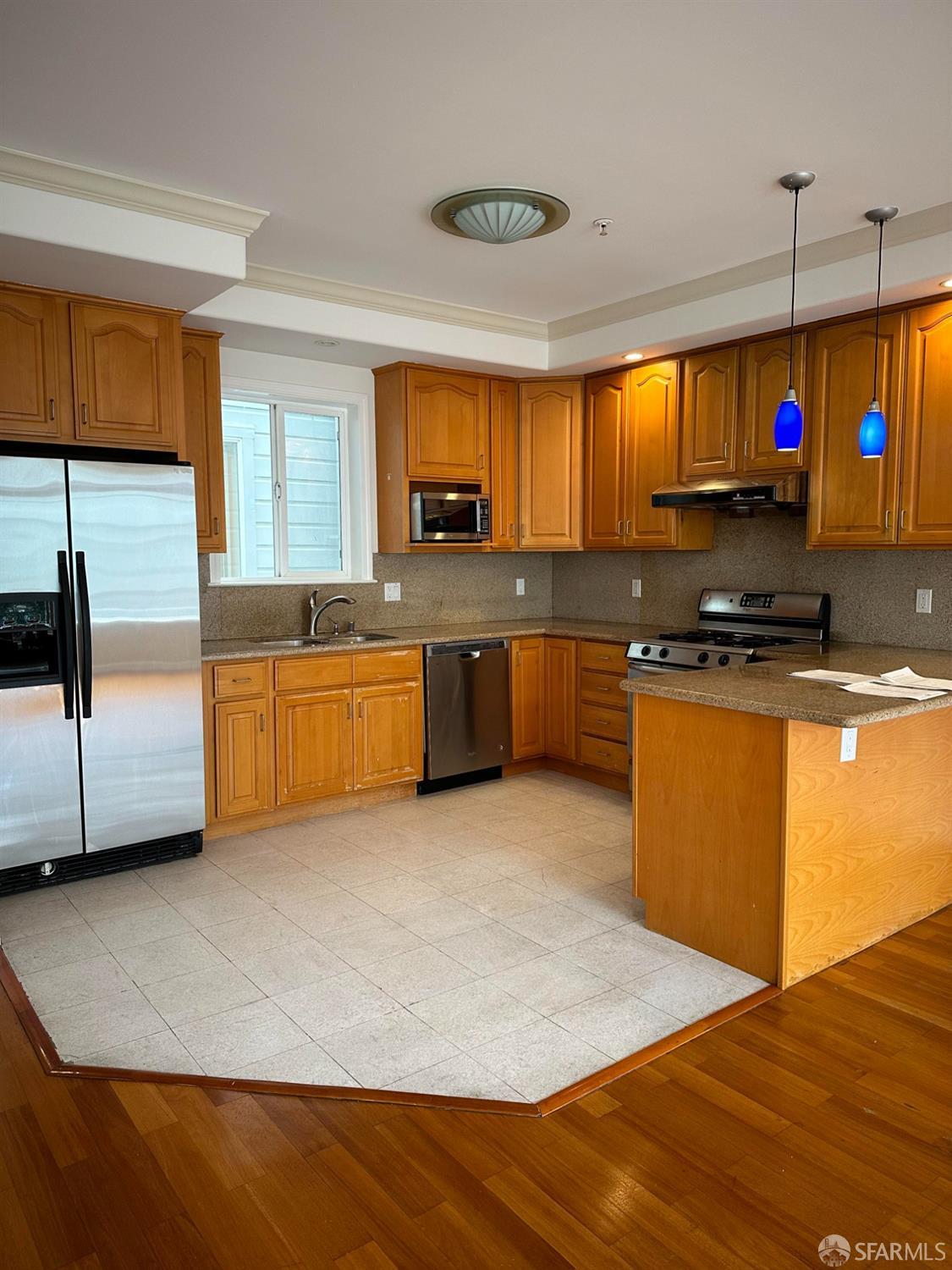 a kitchen with stainless steel appliances granite countertop a stove a sink and a microwave