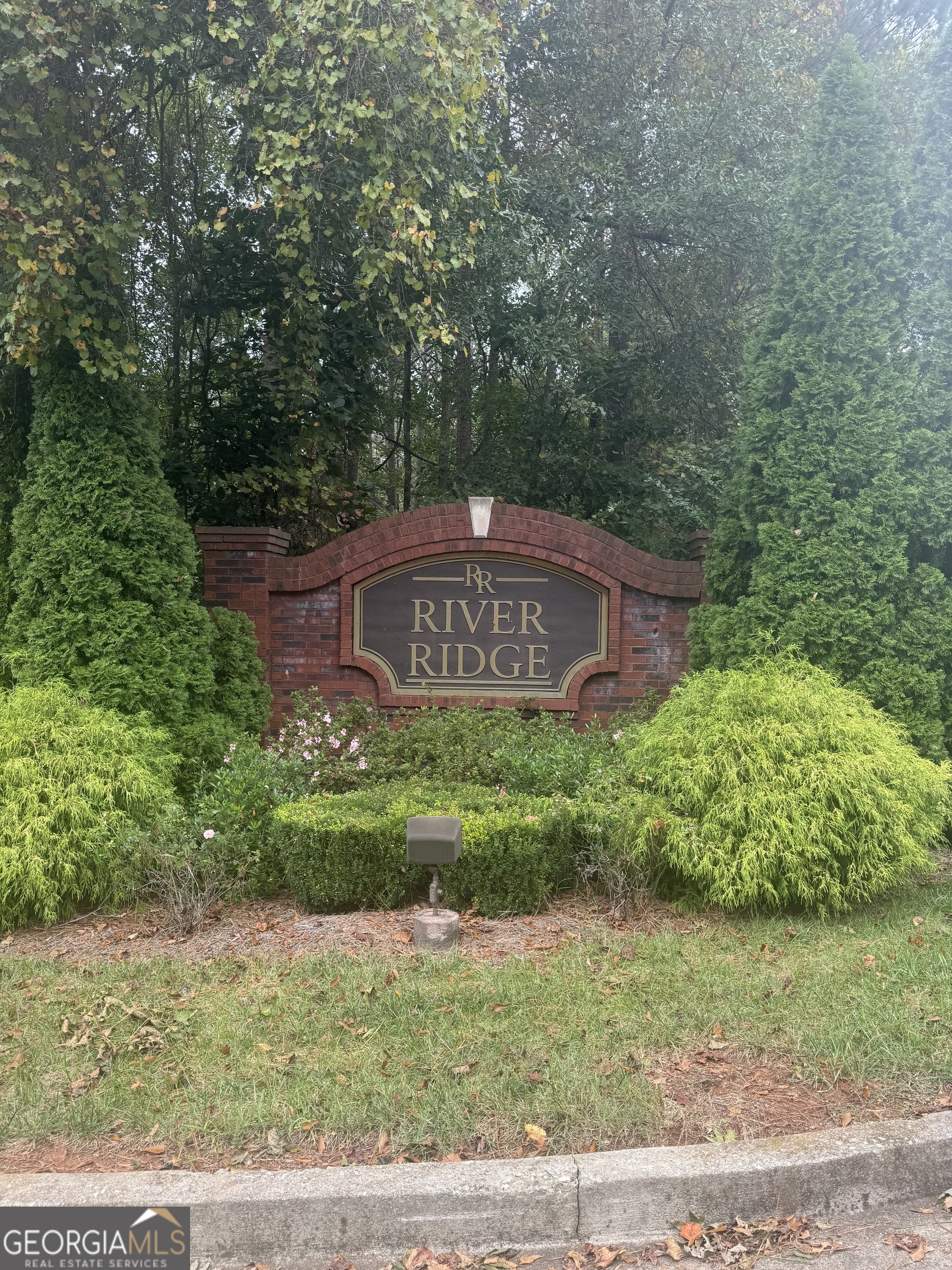 a sign board with a house in the background