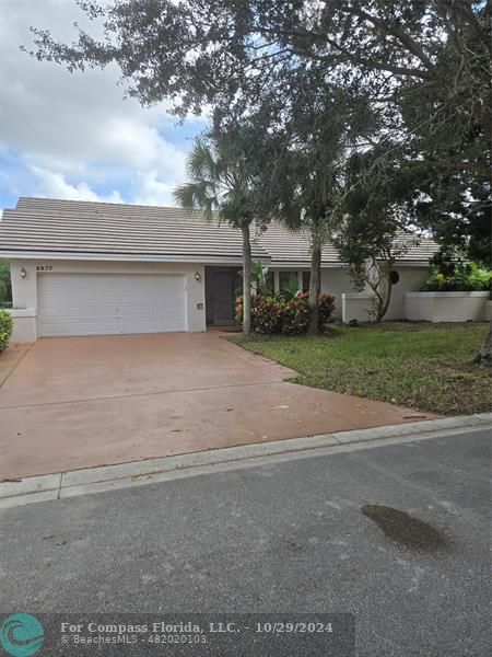 front view of house with a yard and trees