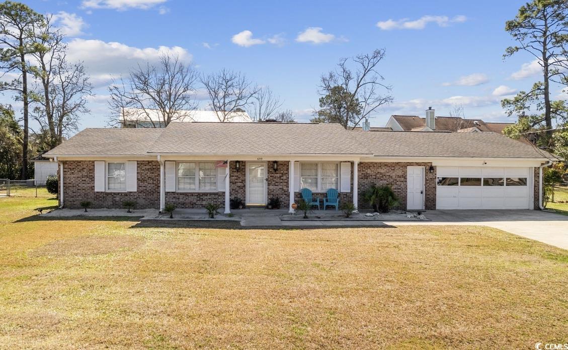 Ranch-style house with a garage, a front lawn, and