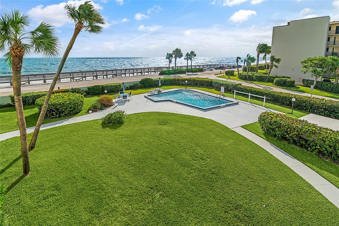 a view of a swimming pool with a garden and ocean view