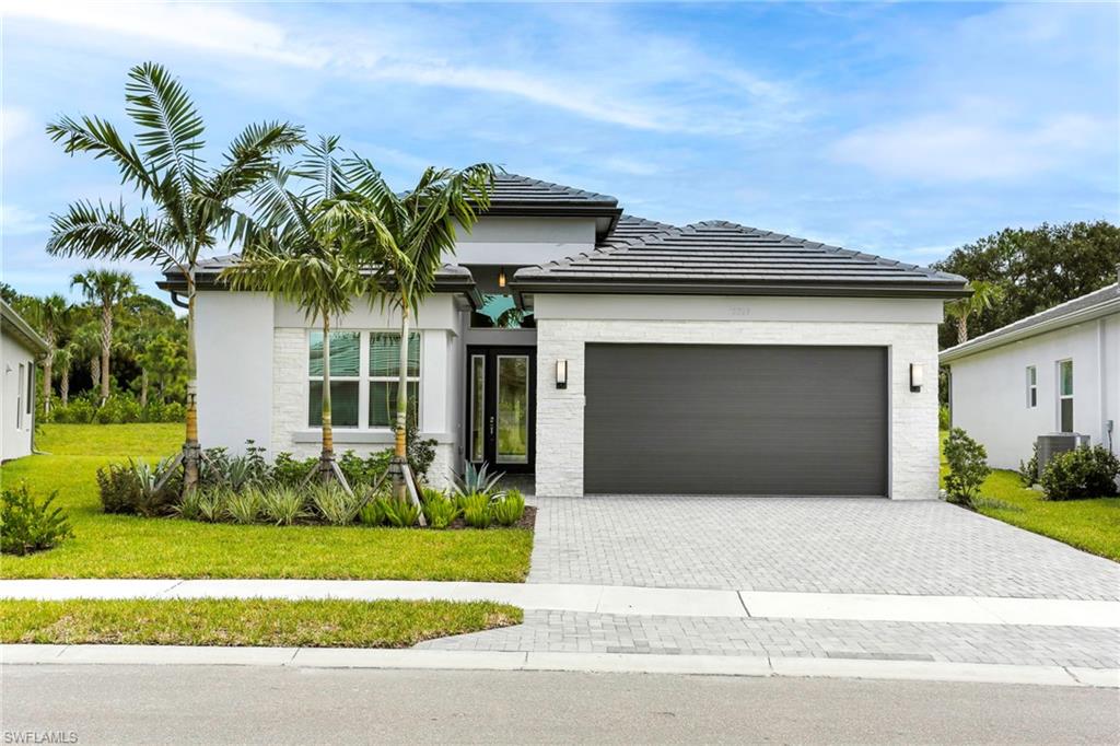 View of front of house with a garage and a front yard