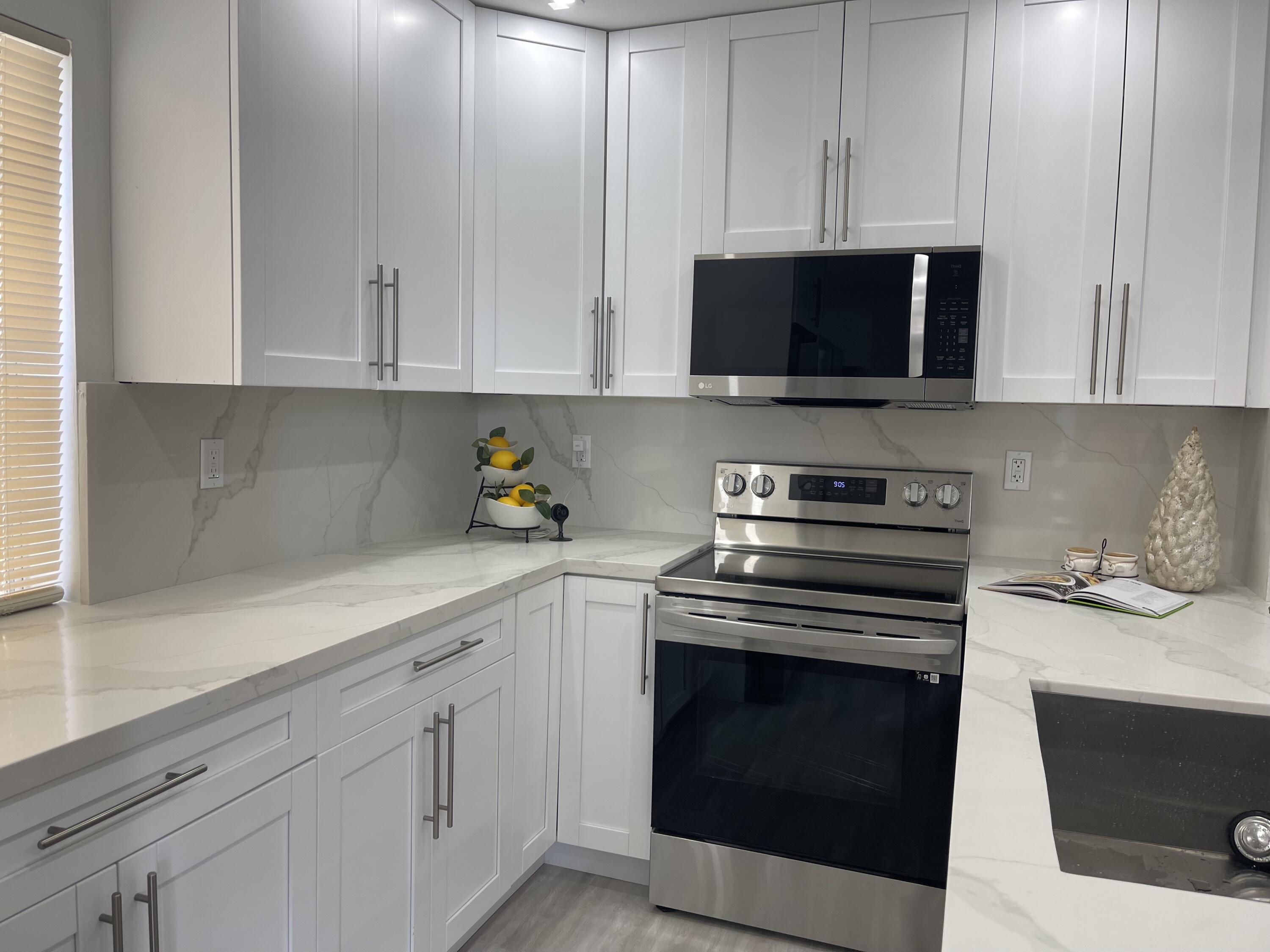 a kitchen with white cabinets and stainless steel appliances