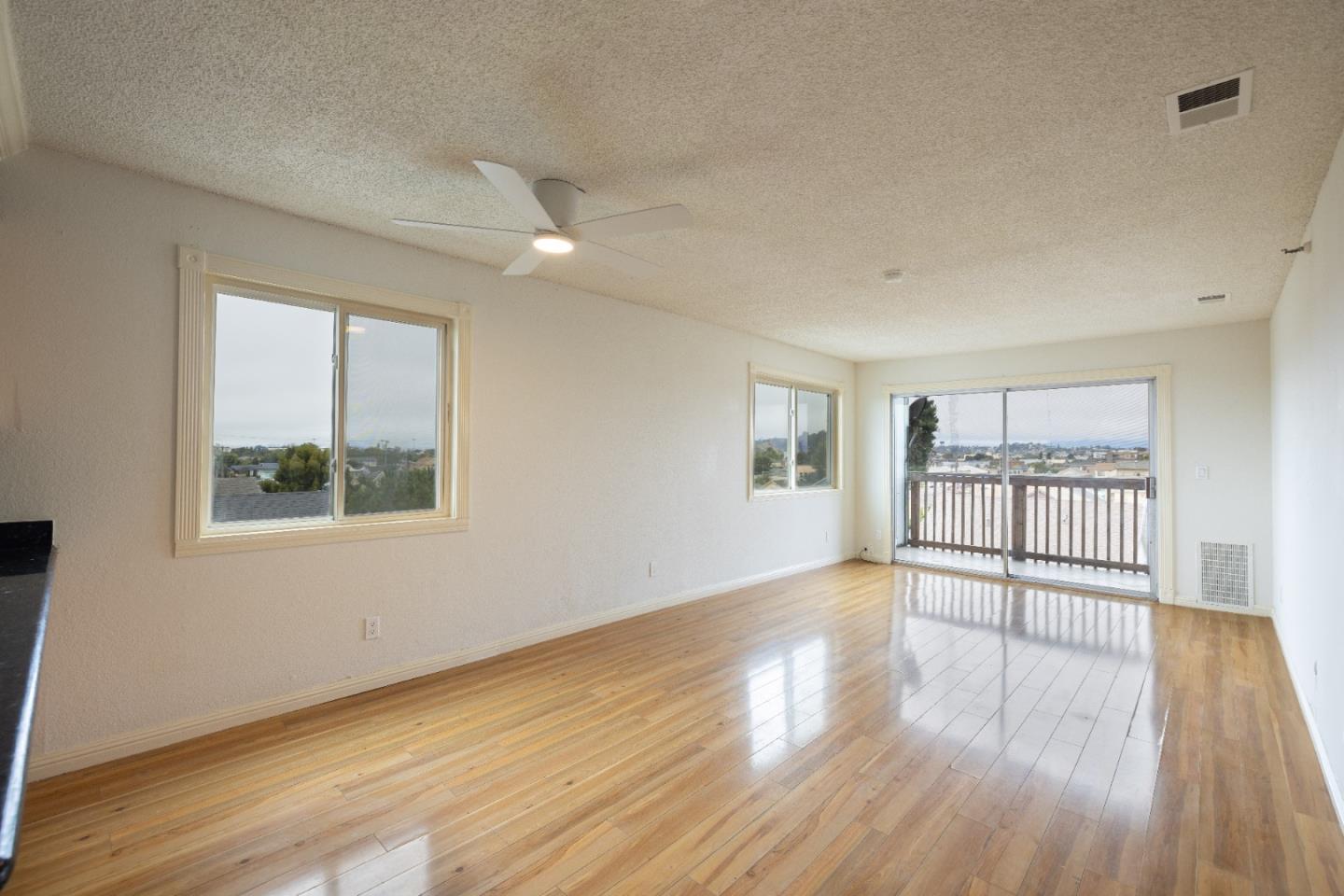 a view of a room with wooden floor and a window