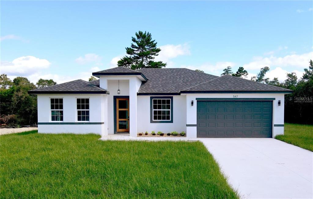 a front view of a house with a garden and yard