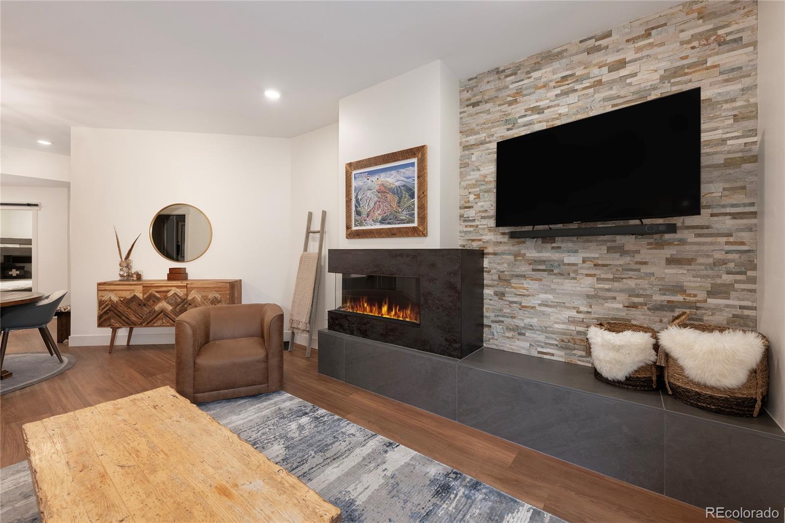 a living room with furniture a flat screen tv and a fireplace