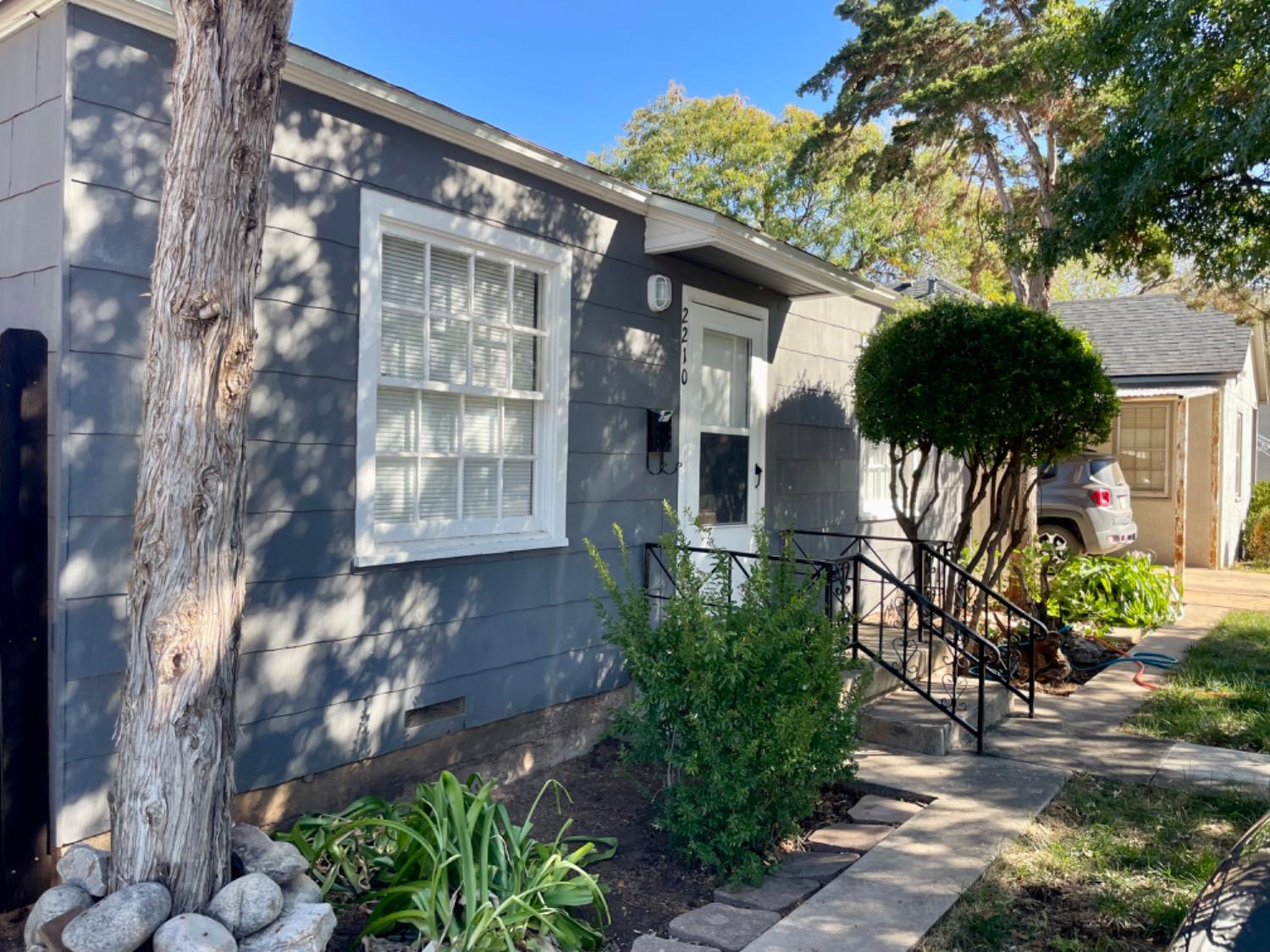 a front view of a house with a tree