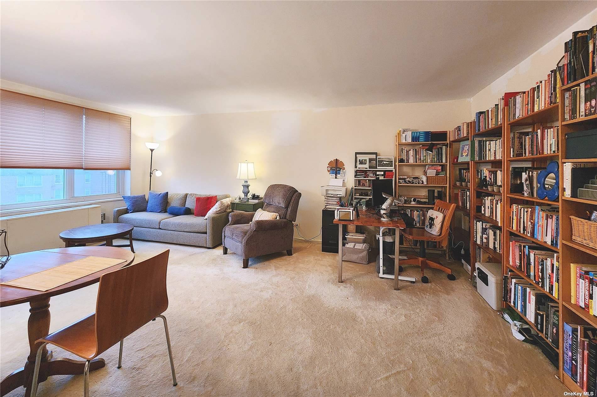 a living room with furniture and a book shelf