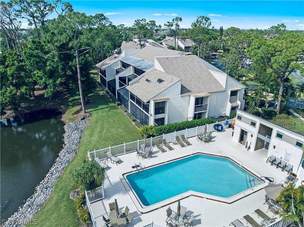 an aerial view of a house with swimming pool and outdoor seating