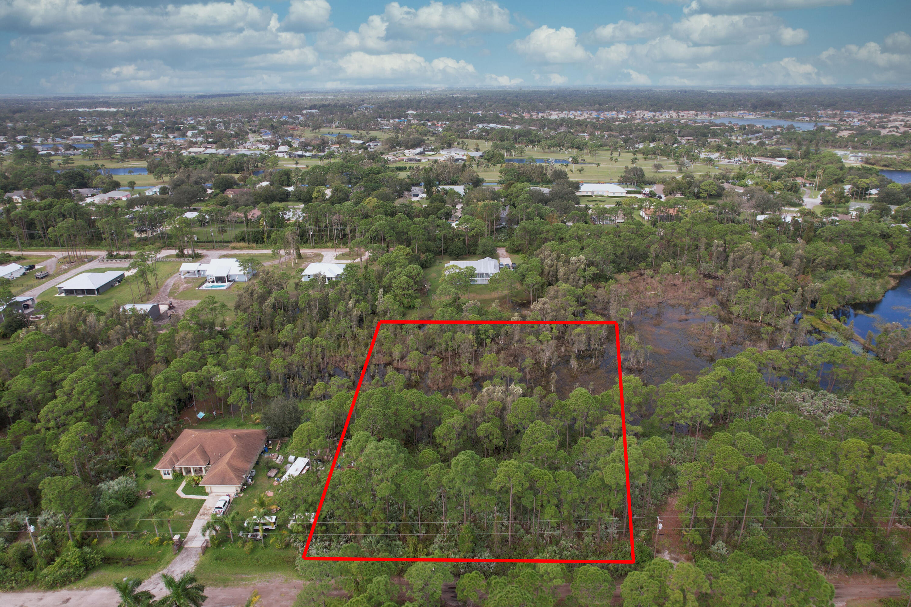 an aerial view of residential houses with outdoor space and trees