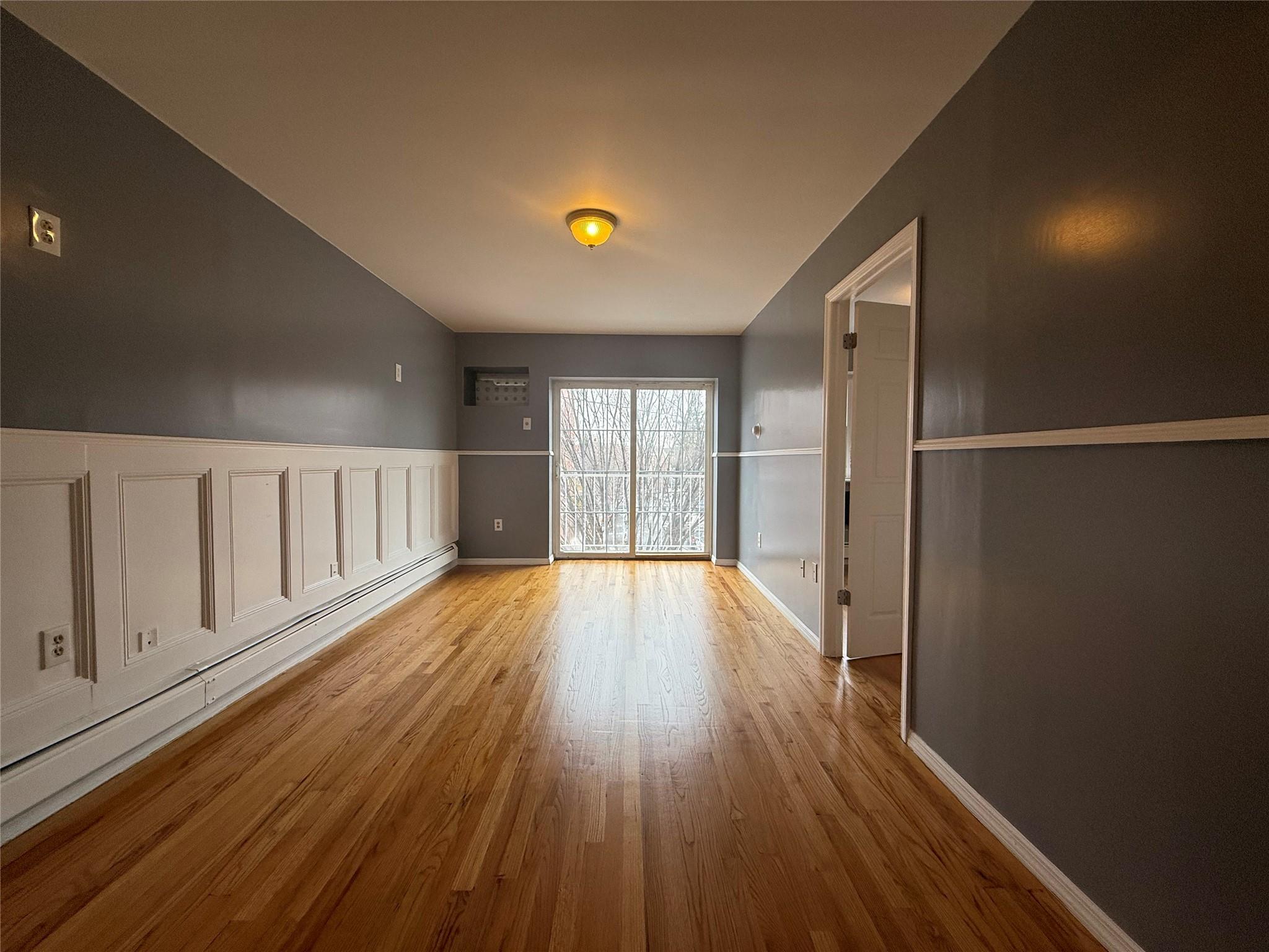 Unfurnished room featuring light hardwood / wood-style floors and a baseboard heating unit