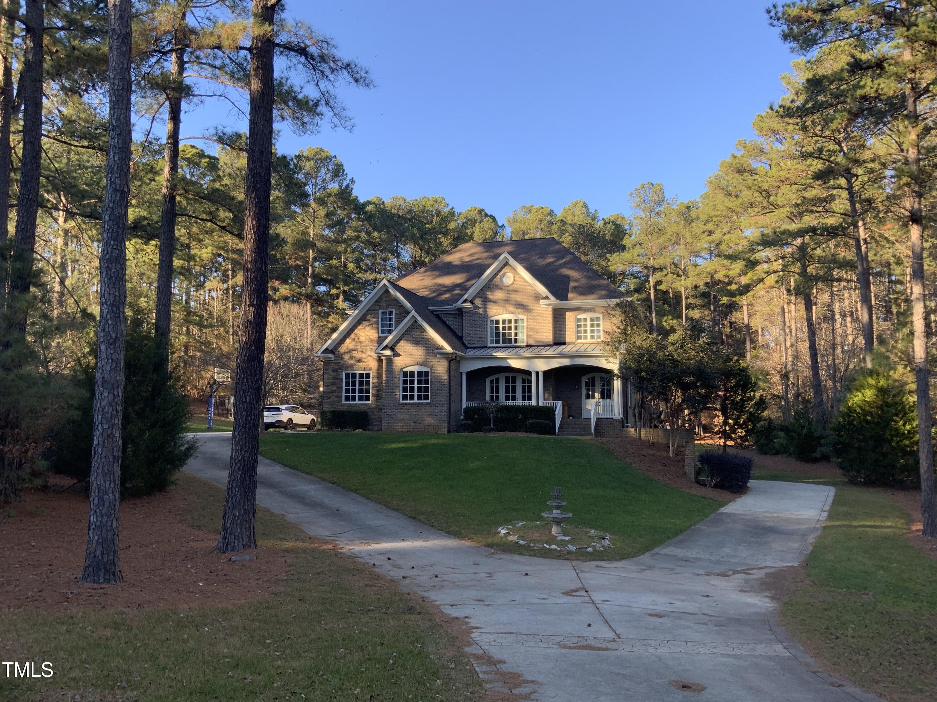 a front view of a house with a garden and trees