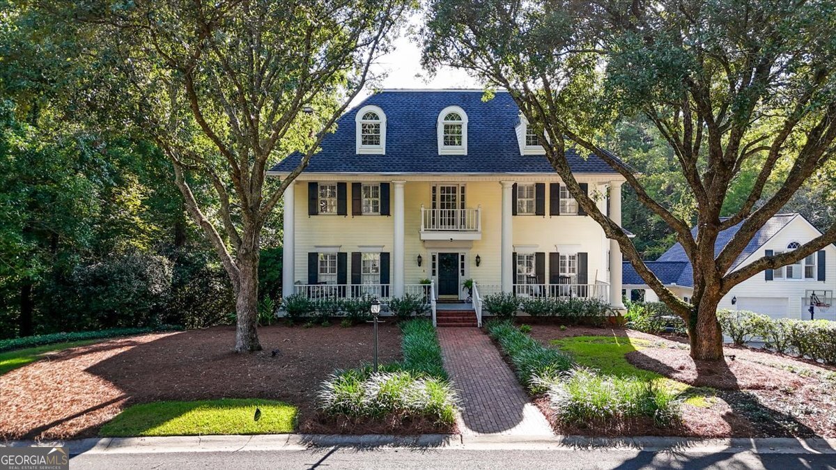 a front view of a house with a yard and potted plants