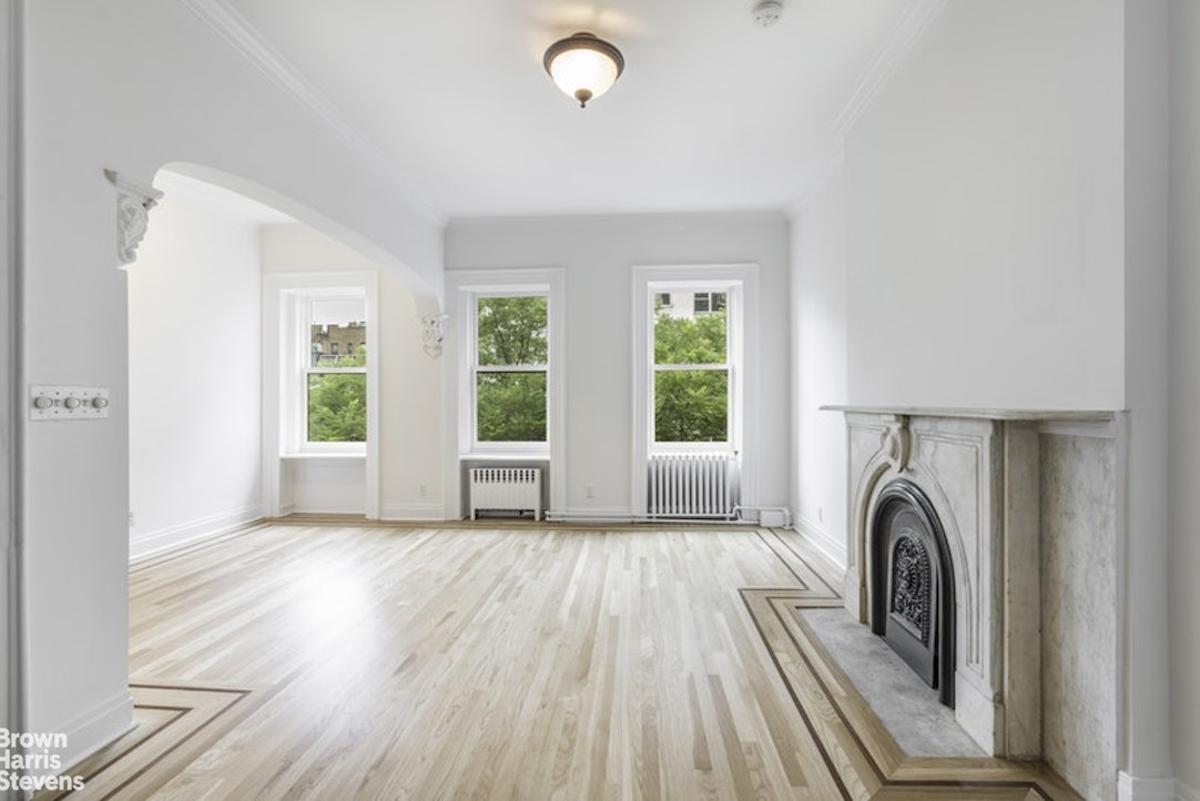 a view of a bedroom with wooden floor and a window