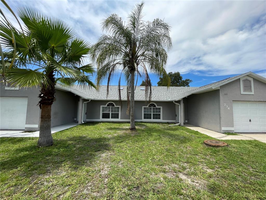 a front view of house with yard and trees