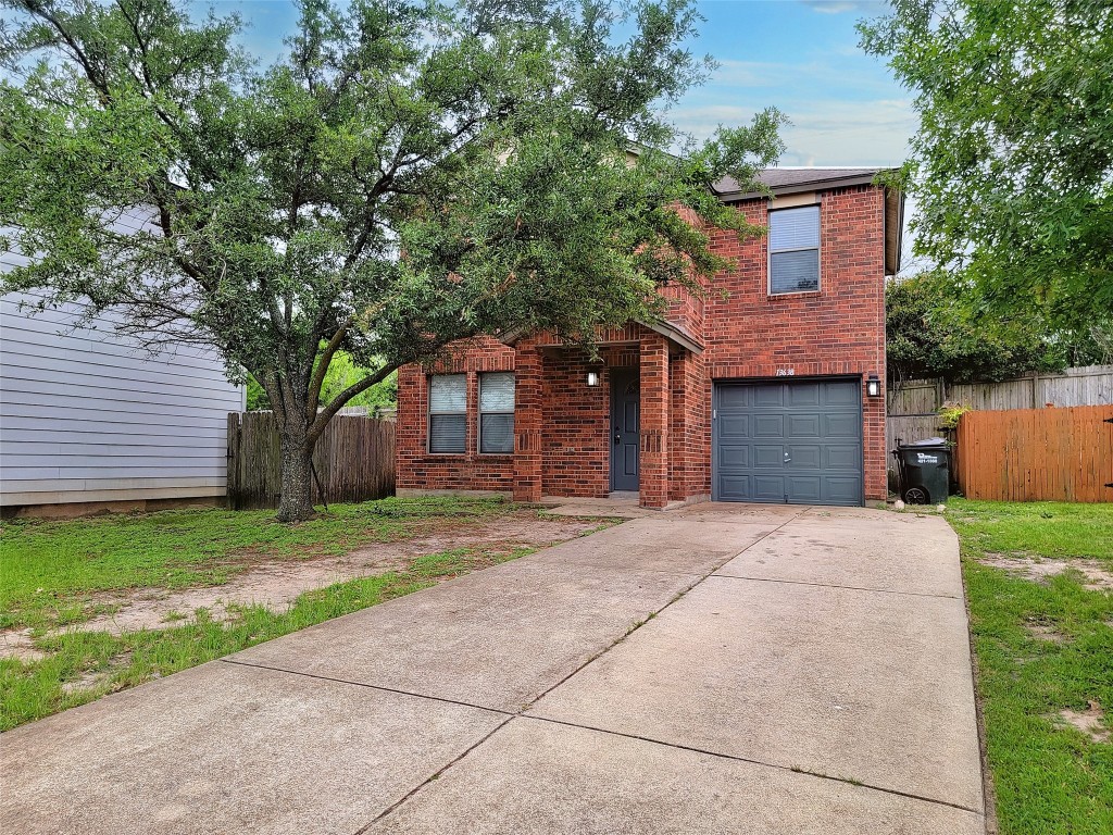 a front view of a house with a garden and trees