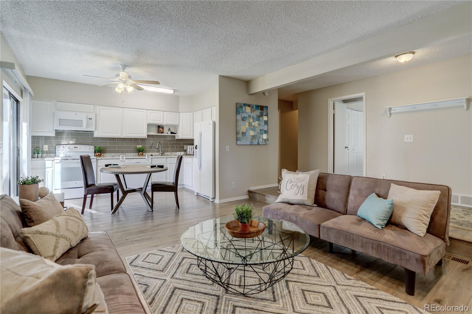 a living room with furniture and a dining table with kitchen view