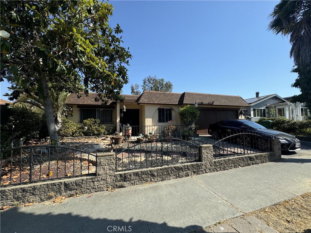 a front view of house with yard outdoor seating and covered with trees