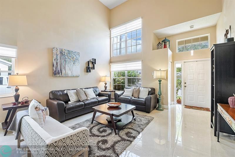 a living room with furniture wooden floor and a large window