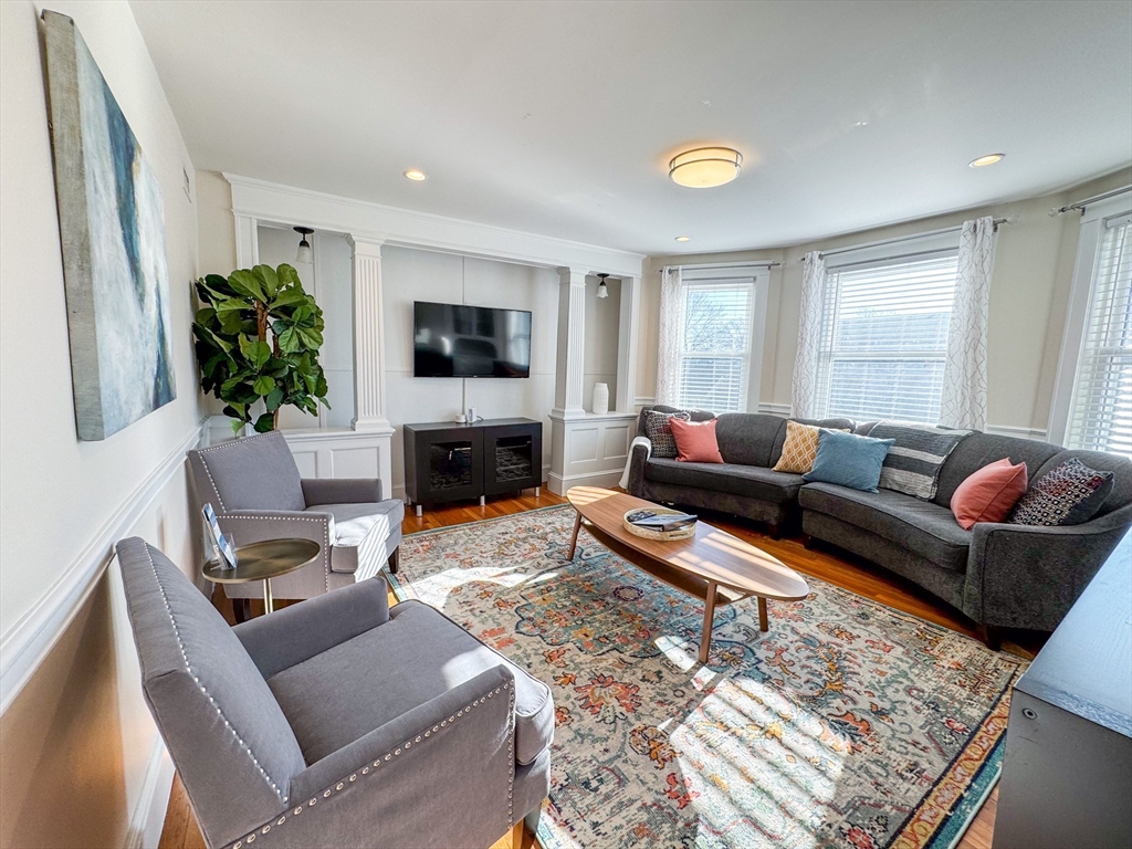 a living room with furniture a fireplace and a flat screen tv