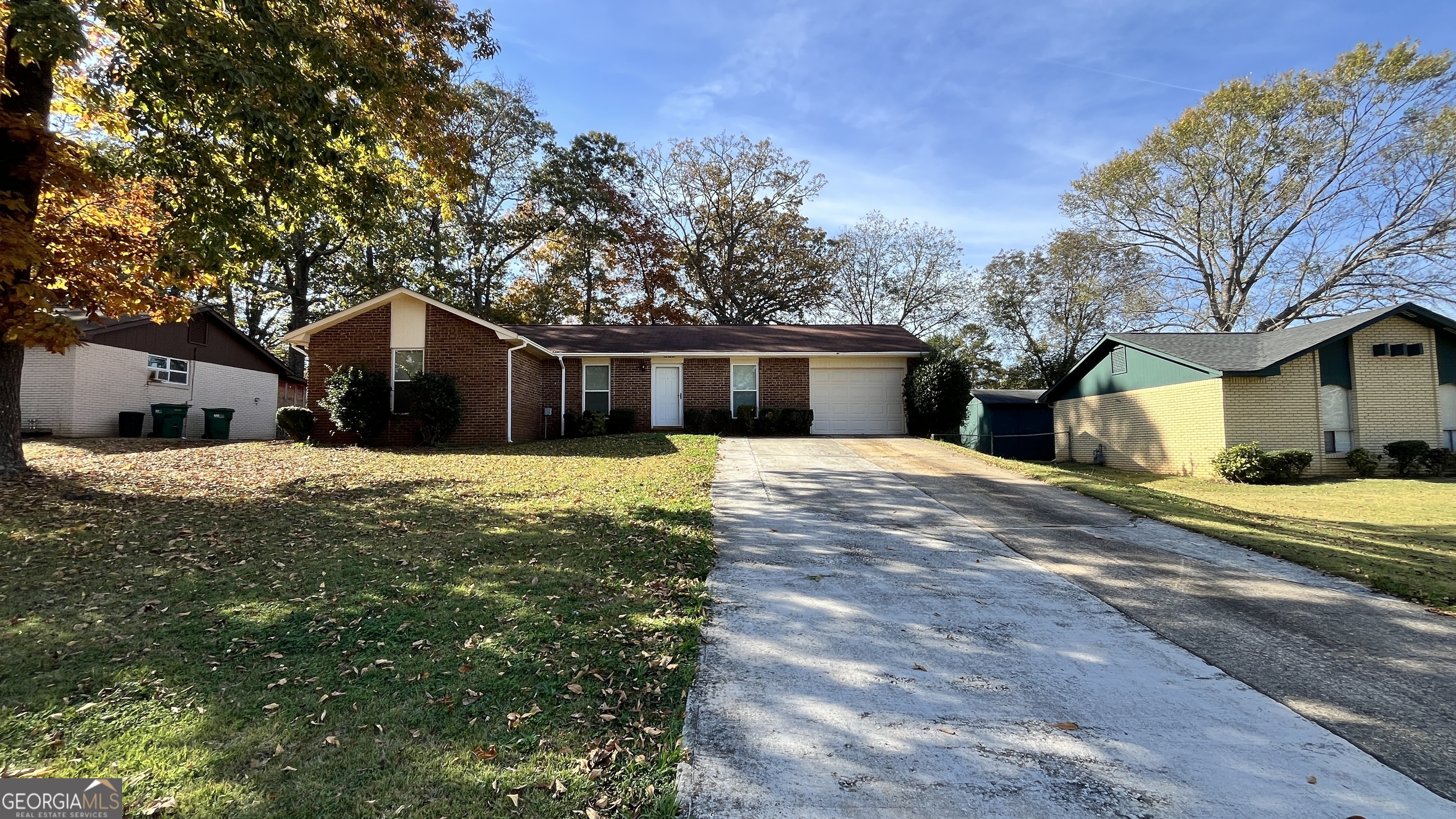 a front view of house with yard and trees around