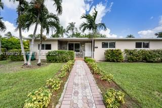 front view of a house with a yard and potted plants