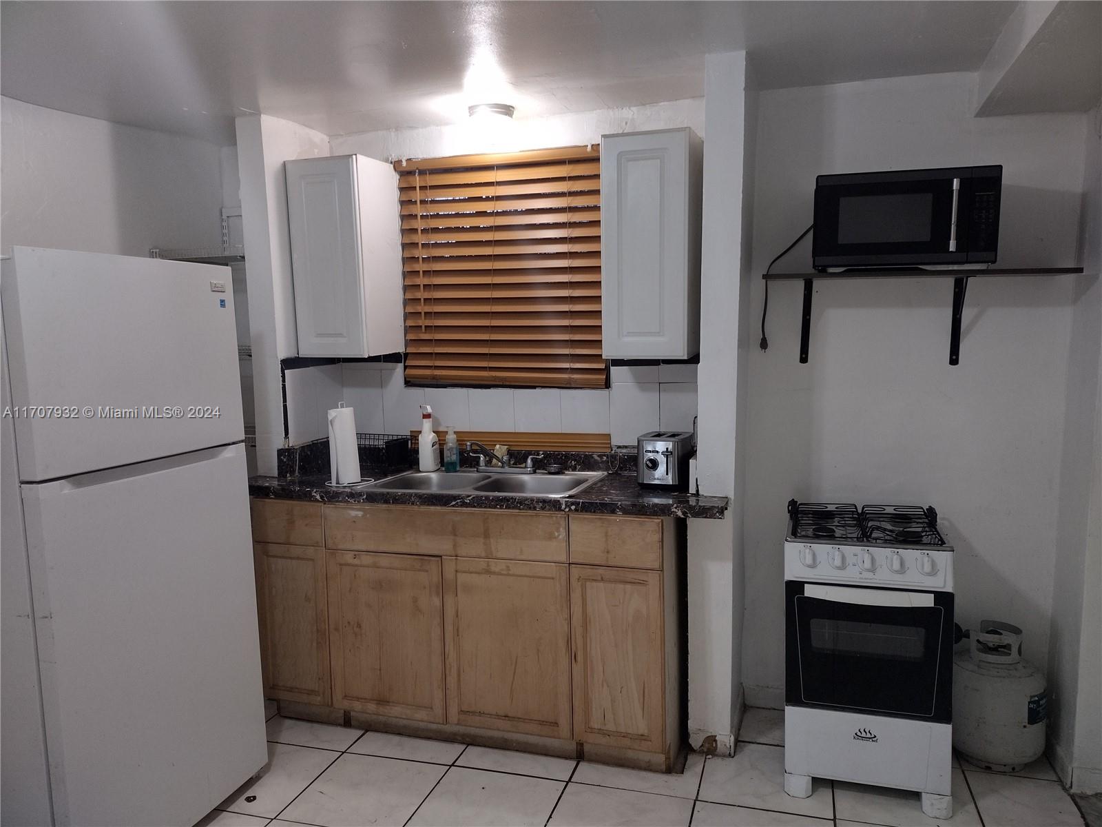 a kitchen with a refrigerator and a stove top oven