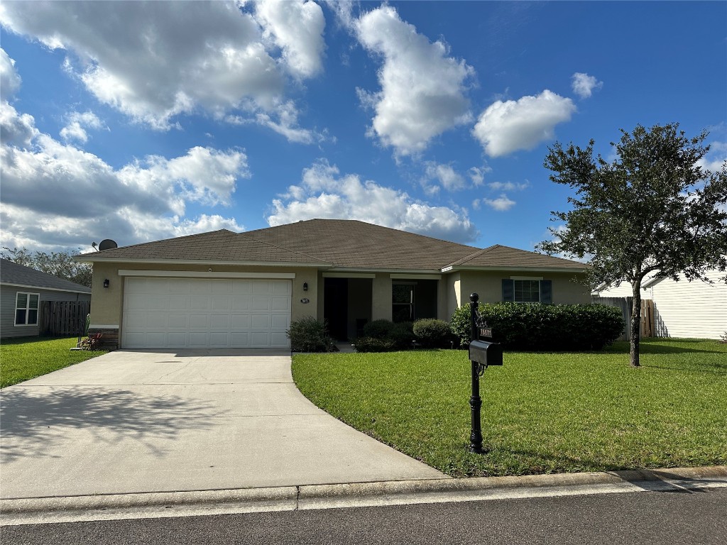 a front view of a house with a yard and garage