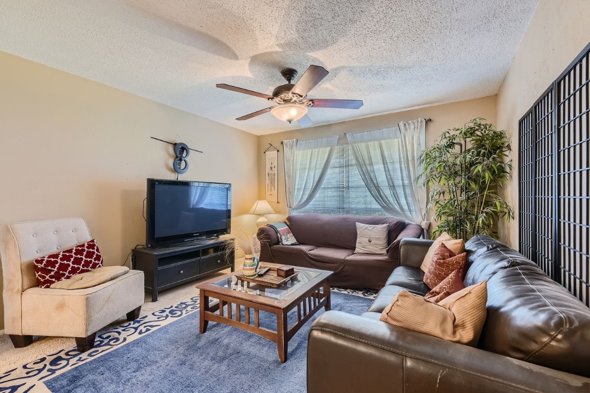 a living room with furniture ceiling fan and a window