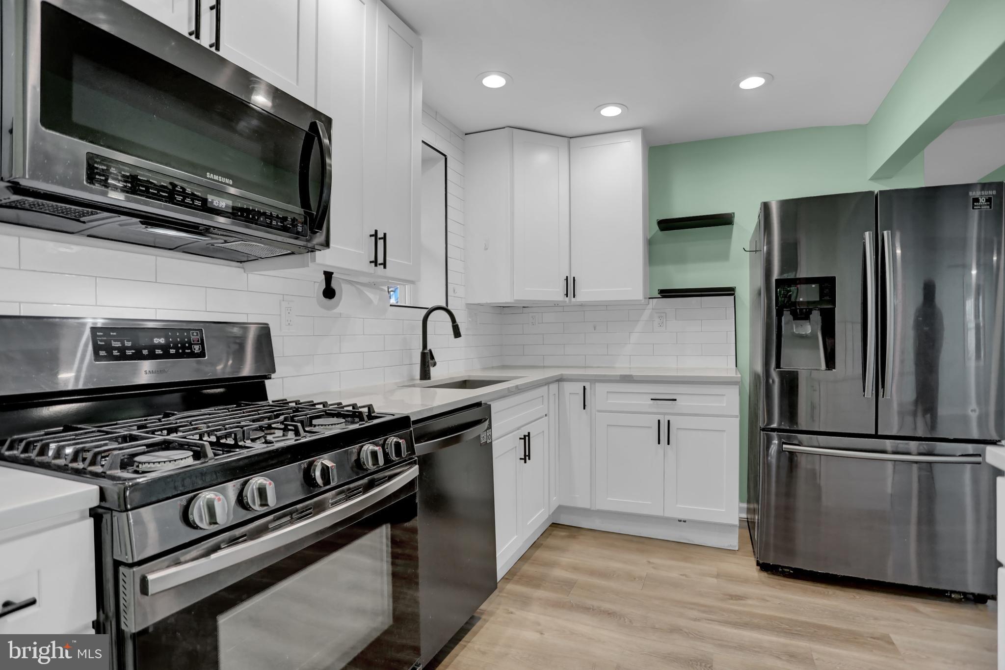 a kitchen with stainless steel appliances granite countertop a stove microwave and refrigerator