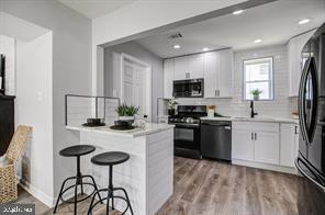 a kitchen with a refrigerator a stove a sink and chairs