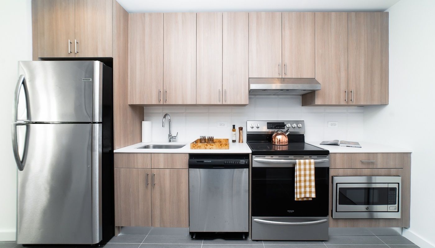 a kitchen with stainless steel appliances granite countertop a refrigerator and a stove